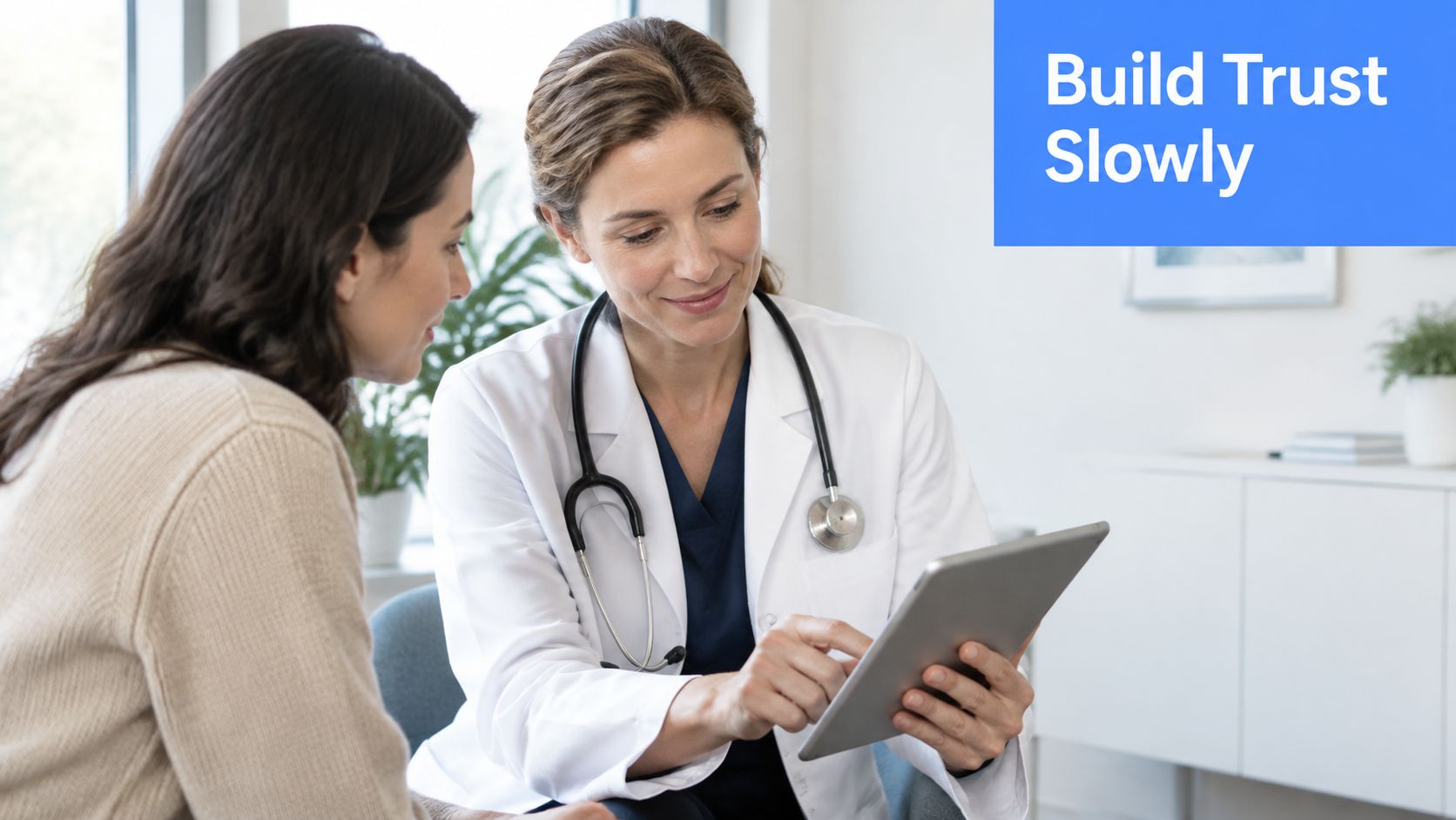 A female doctor in a white coat showing a digital tablet to a patient during consultation.