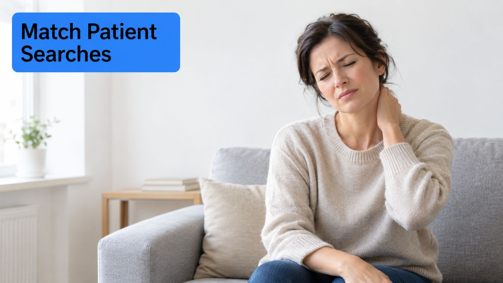 A woman sitting on a sofa while feeling pain in her neck and touching it.