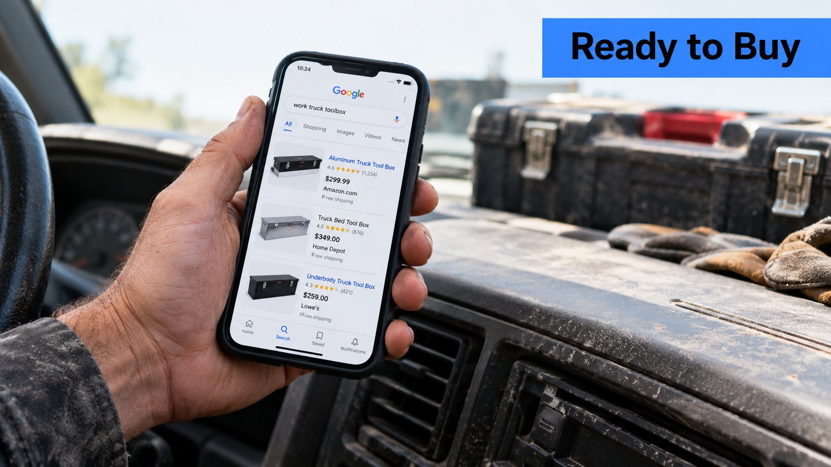 A person holding a smartphone showing Google search results for work truck toolboxes inside a vehicle cabin.